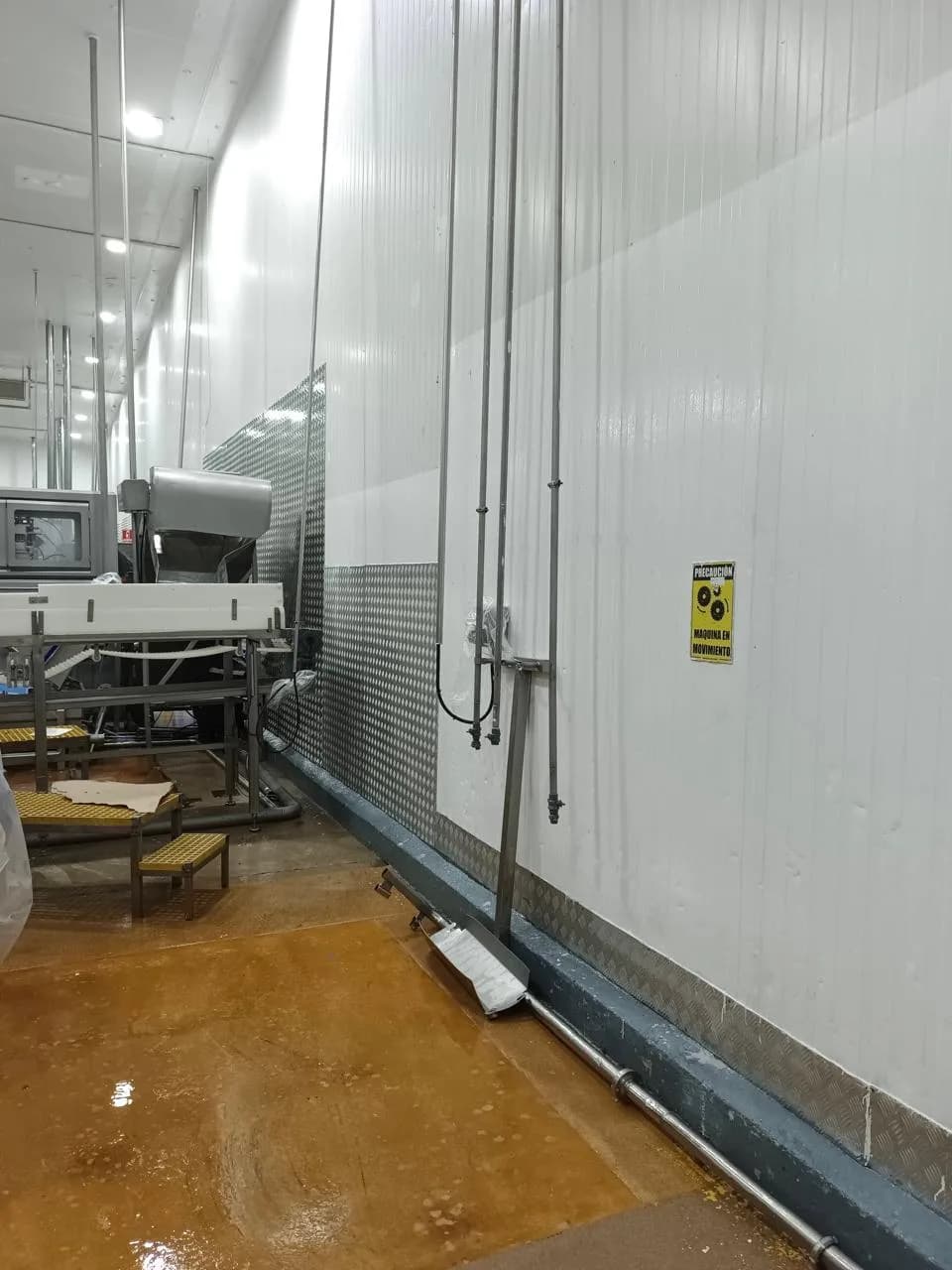 Pasillo de planta de alimentos con paredes pintadas y maquinaria en operación